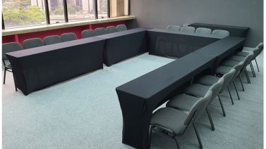 sala para eventos corporativos, com uma mesa em U e várias cadeiras ao redor