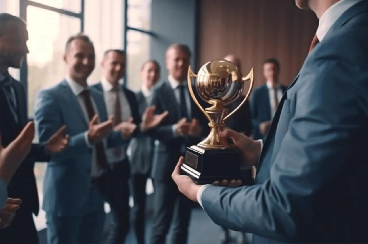 homem segurando troféu e diversas pessoas aplaudindo