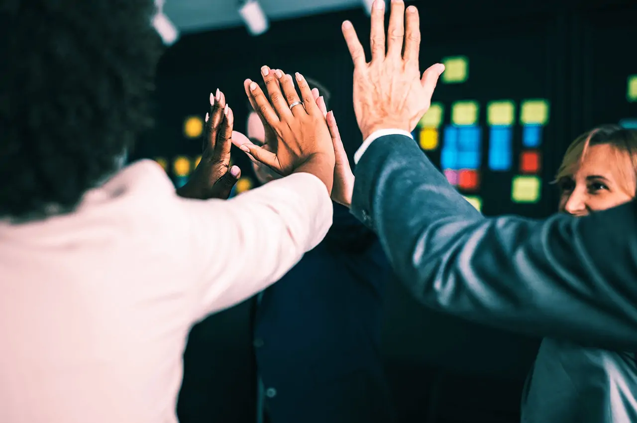 pessoas tocando as mãos em uma gamificação em evento corporativo