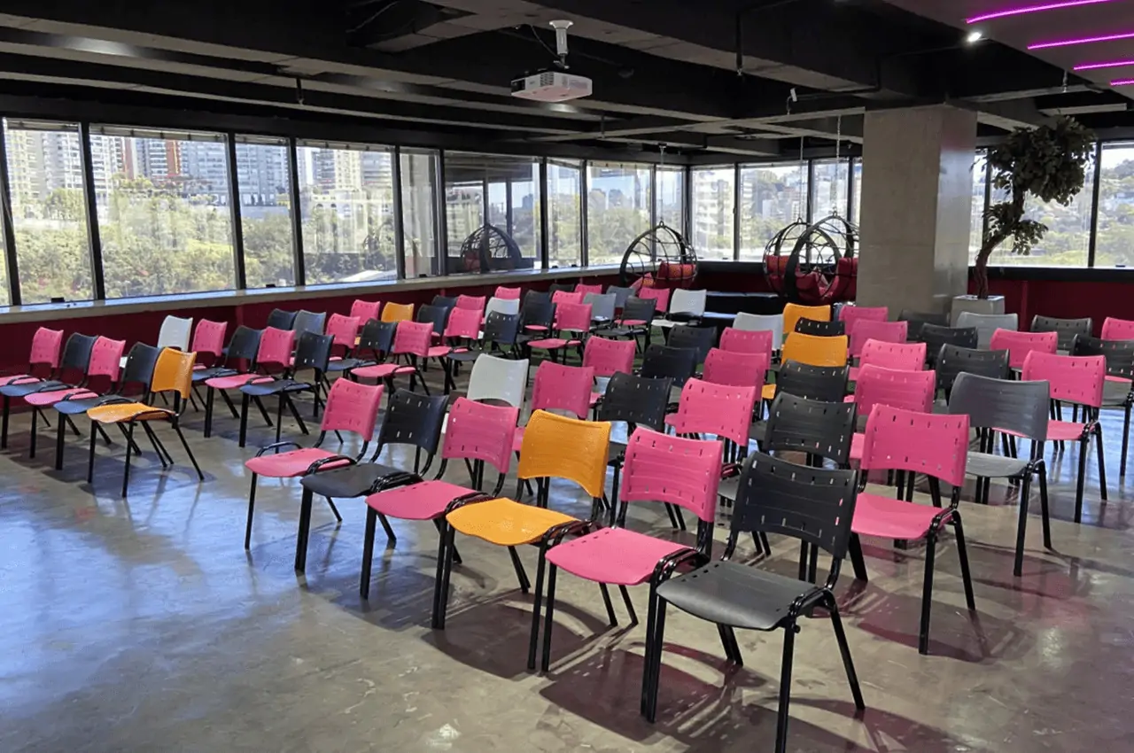 cadeiras coloridas em uma sala ampla com janelas de vidro