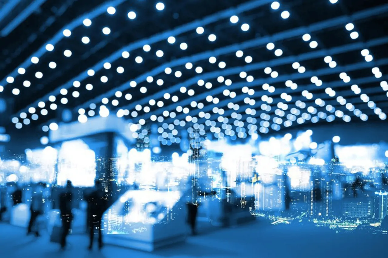 espaço de eventos com pessoas e várias luzes no teto