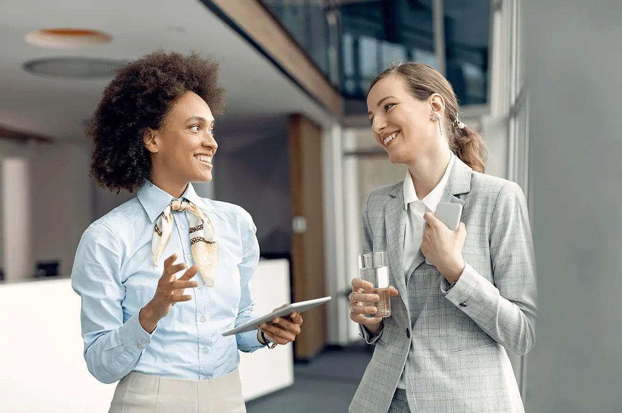 duas mulheres sorridentes conversando no evento corporativo