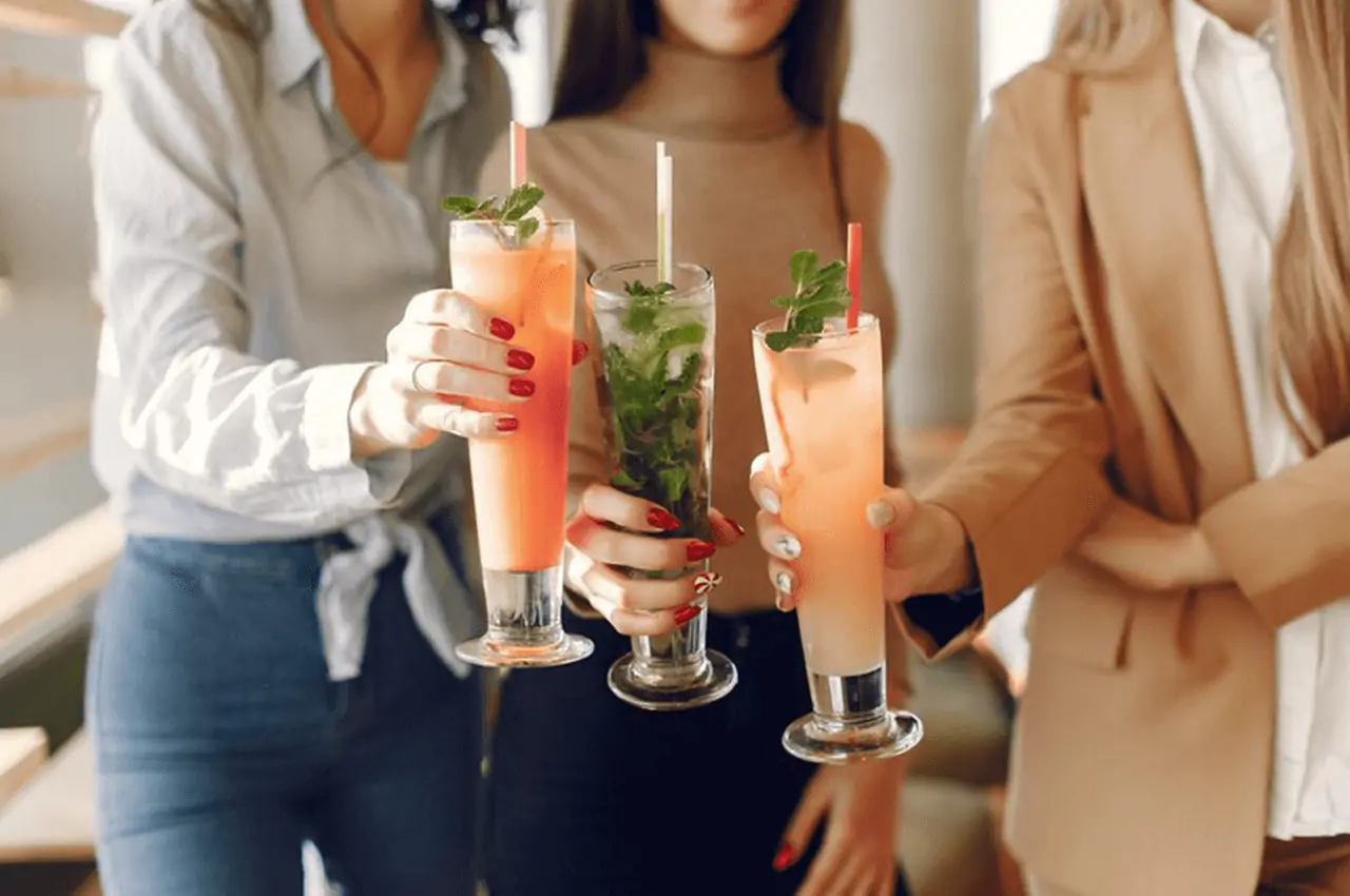 mulheres de pé segurando taças com bebidas